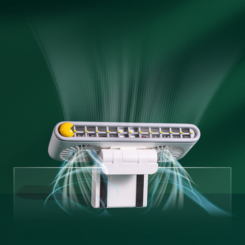 Clip fan attached to a laptop screen at a desk