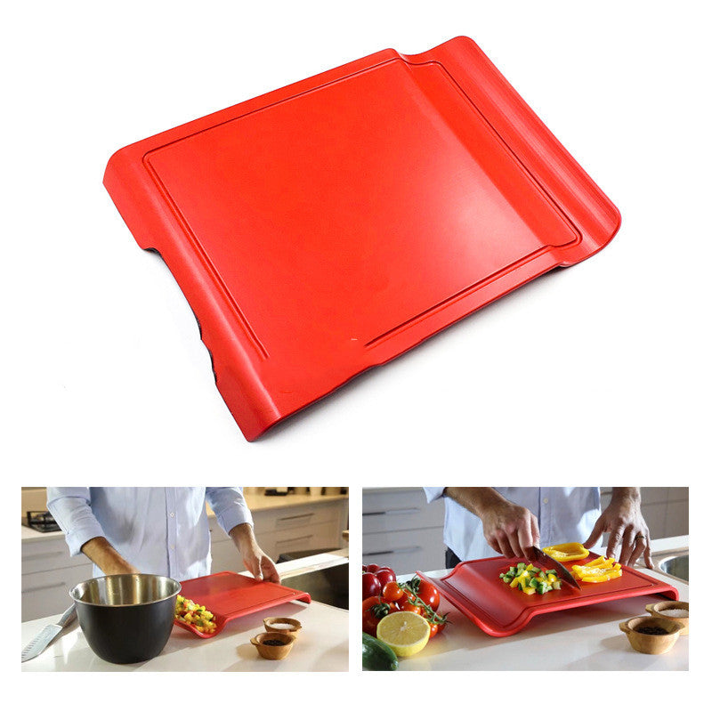 Foldable cutting board folded in half to pour chopped vegetables